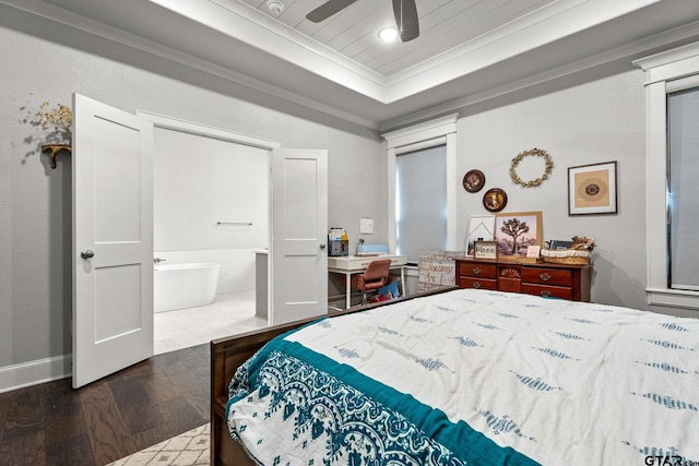 bedroom featuring a tray ceiling, dark wood-type flooring, ceiling fan, ensuite bathroom, and crown molding