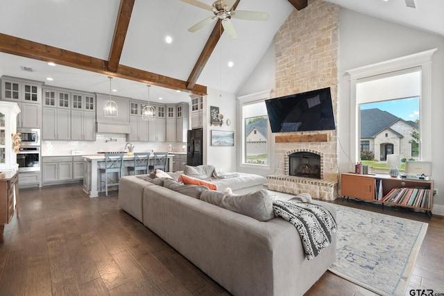 living room with beamed ceiling, high vaulted ceiling, a stone fireplace, and dark hardwood / wood-style flooring