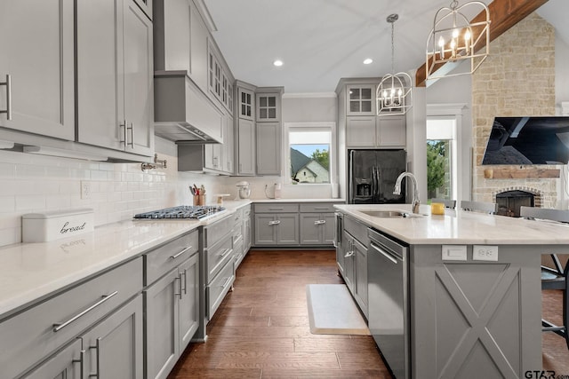 kitchen with gray cabinetry, a breakfast bar, sink, an island with sink, and stainless steel appliances