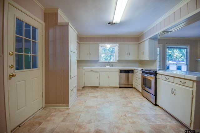 kitchen with white cabinets, sink, ornamental molding, and stainless steel appliances