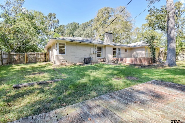 back of property featuring cooling unit and a lawn