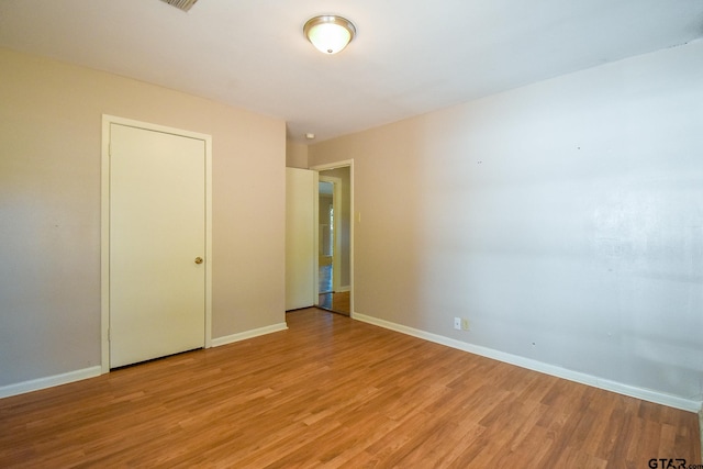 unfurnished bedroom featuring a closet and light hardwood / wood-style flooring