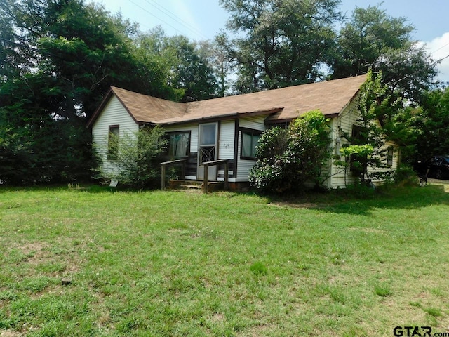 rear view of house featuring a yard