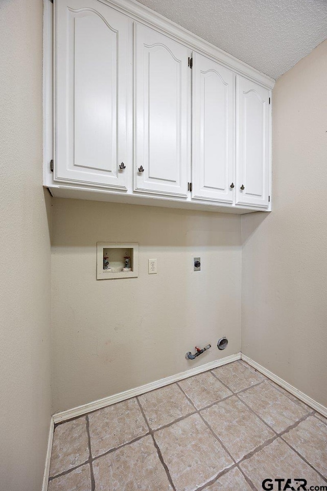 laundry room featuring cabinets, washer hookup, hookup for an electric dryer, hookup for a gas dryer, and a textured ceiling