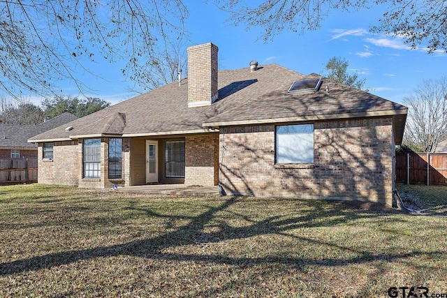 rear view of house with a yard and a patio