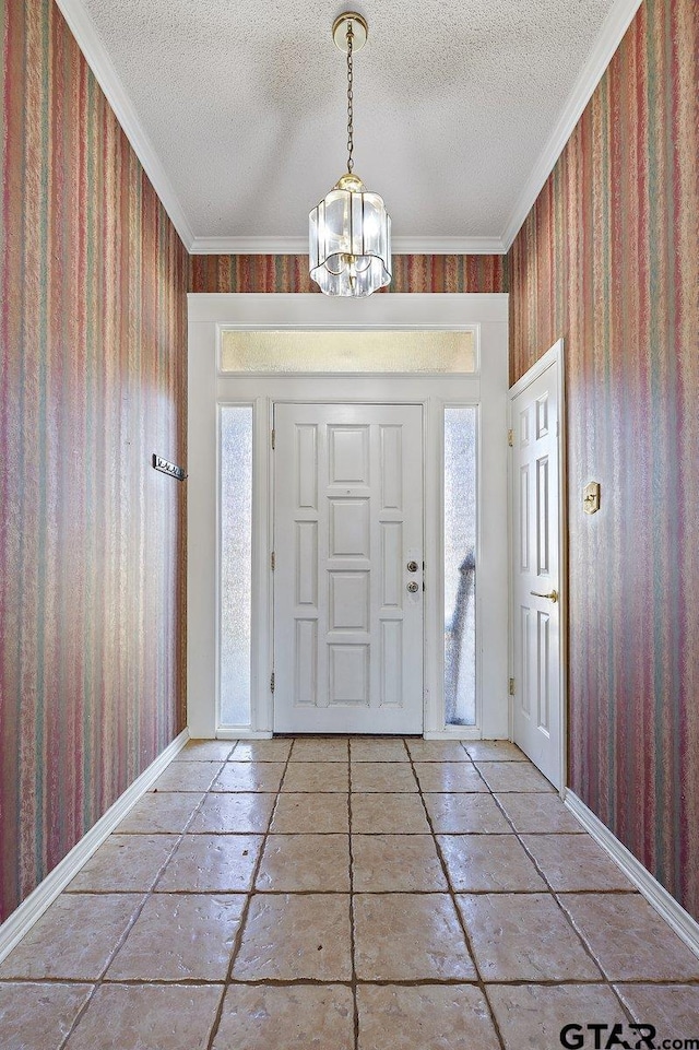 foyer entrance featuring a healthy amount of sunlight, a chandelier, a textured ceiling, and ornamental molding