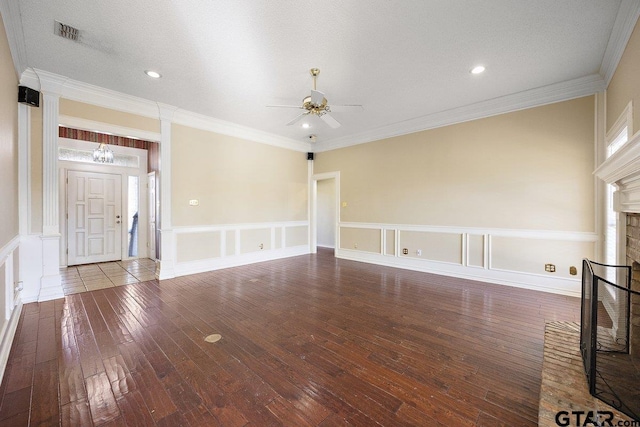 unfurnished living room with ceiling fan, ornamental molding, a textured ceiling, and a brick fireplace