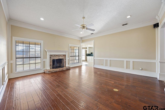 unfurnished living room with crown molding, a fireplace, wood-type flooring, and a textured ceiling