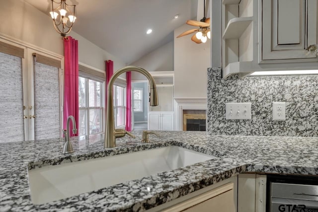 kitchen with ceiling fan, sink, backsplash, and lofted ceiling