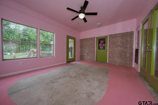 carpeted spare room with ceiling fan, brick wall, and ornamental molding