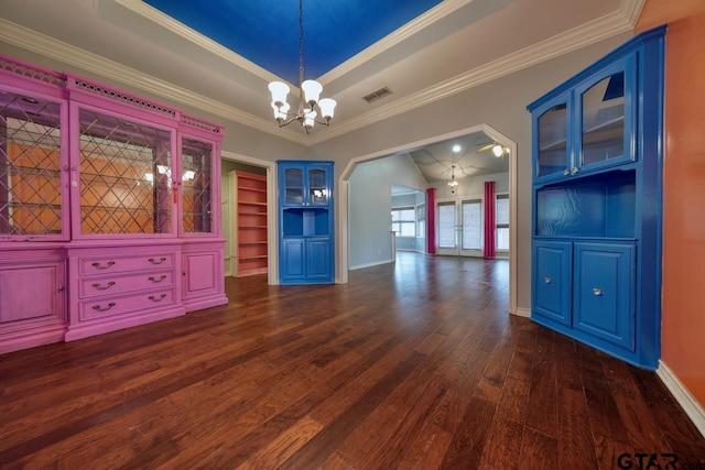 unfurnished room featuring a tray ceiling, ornamental molding, dark hardwood / wood-style flooring, and a notable chandelier