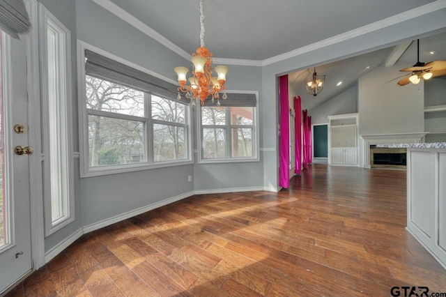 unfurnished dining area featuring vaulted ceiling, crown molding, plenty of natural light, and wood-type flooring