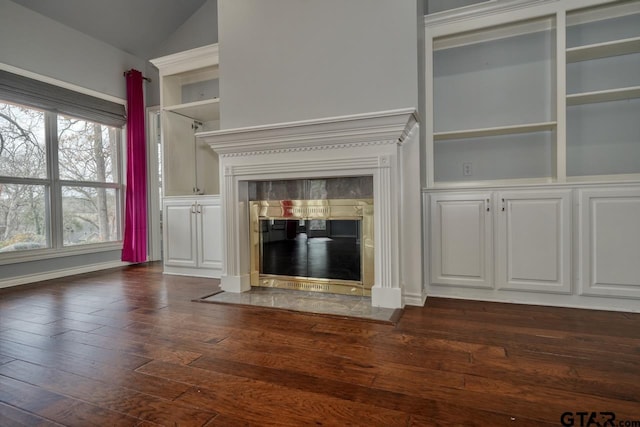 unfurnished living room featuring vaulted ceiling, dark hardwood / wood-style flooring, and a fireplace