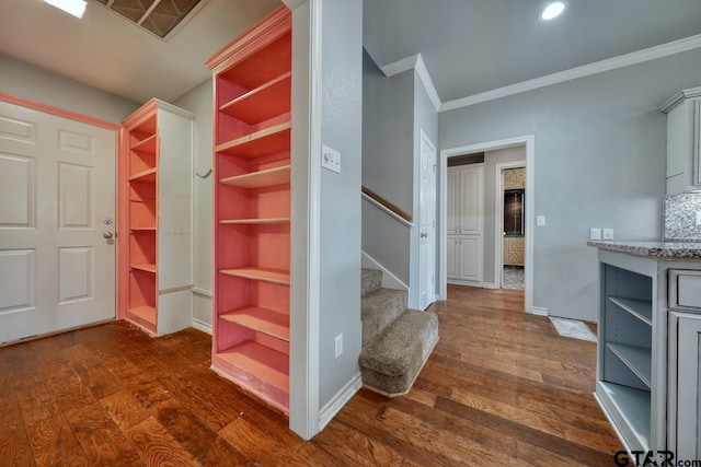 stairway featuring hardwood / wood-style floors and ornamental molding