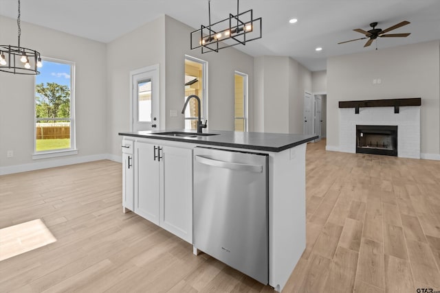 16509 Crossing Cir, Lindale, TX 75771 - kitchen featuring stainless steel dishwasher, a chandelier, dark countertops, light wood-type flooring, and an island with sink