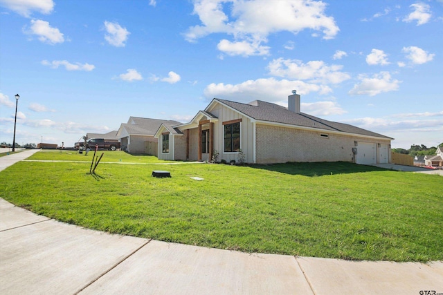 16509 Crossing Cir, Lindale, TX 75771 - view of home's exterior with an attached garage, a yard, a chimney, and driveway