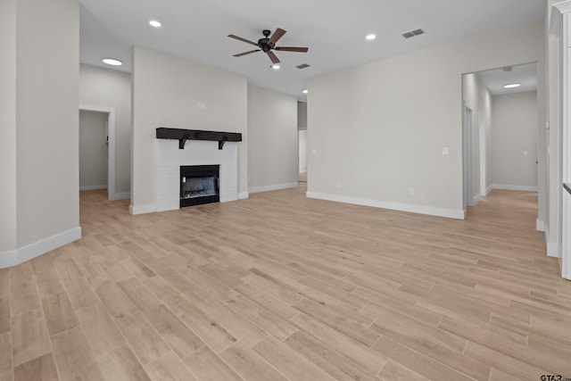 16509 Crossing Cir, Lindale, TX 75771 - unfurnished living room with ceiling fan, light wood finished floors, a fireplace, and recessed lighting
