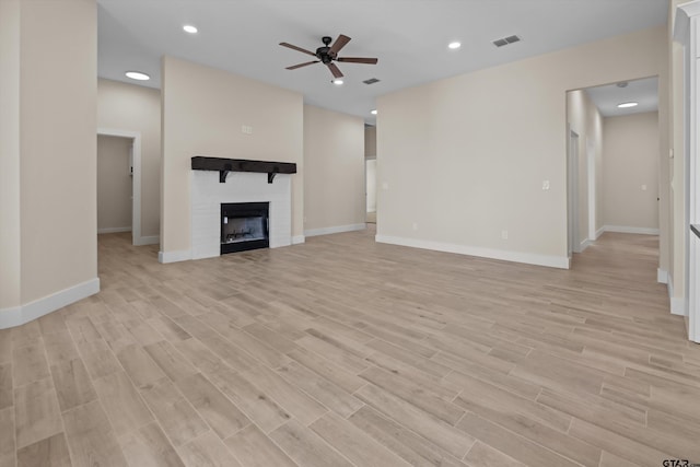 16509 Crossing Cir, Lindale, TX 75771 - unfurnished living room with ceiling fan, light wood-type flooring, a large fireplace, and recessed lighting