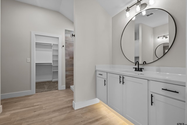 16509 Crossing Cir, Lindale, TX 75771 - full bath with vanity, wood finished floors, a walk in closet, a tile shower, and lofted ceiling