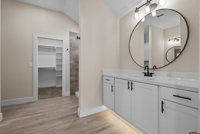 16509 Crossing Cir, Lindale, TX 75771 - full bathroom featuring vanity, tiled shower, wood finished floors, a spacious closet, and vaulted ceiling