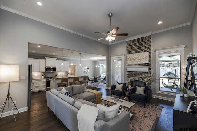 7317 Hearthstone Ln, Tyler, TX 75703 - living area with a fireplace, dark wood-style flooring, plenty of natural light, a ceiling fan, and crown molding