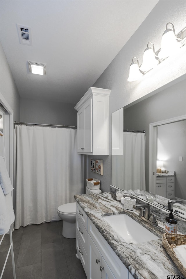 7317 Hearthstone Ln, Tyler, TX 75703 - full bathroom with vanity, a textured wall, tile patterned flooring, and a shower with shower curtain