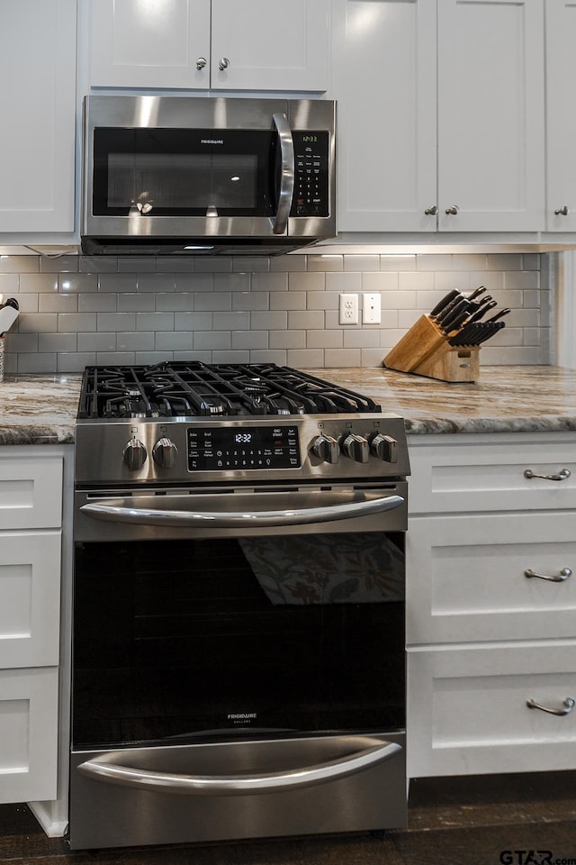 7317 Hearthstone Ln, Tyler, TX 75703 - kitchen with stainless steel appliances, white cabinets, light stone countertops, and backsplash