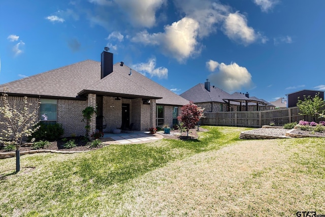 7317 Hearthstone Ln, Tyler, TX 75703 - back of property featuring brick siding, a patio, a shingled roof, and a chimney