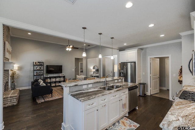 7317 Hearthstone Ln, Tyler, TX 75703 - kitchen featuring appliances with stainless steel finishes, crown molding, open floor plan, a center island with sink, and dark wood-type flooring