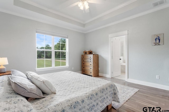 15988 C R 1151, Tyler, TX 75704 - bedroom featuring wood finished floors, a tray ceiling, crown molding, a ceiling fan, and ensuite bath