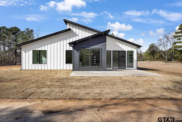 rear view of property featuring a yard and a patio area