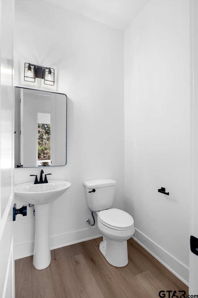 bathroom featuring wood-type flooring and toilet