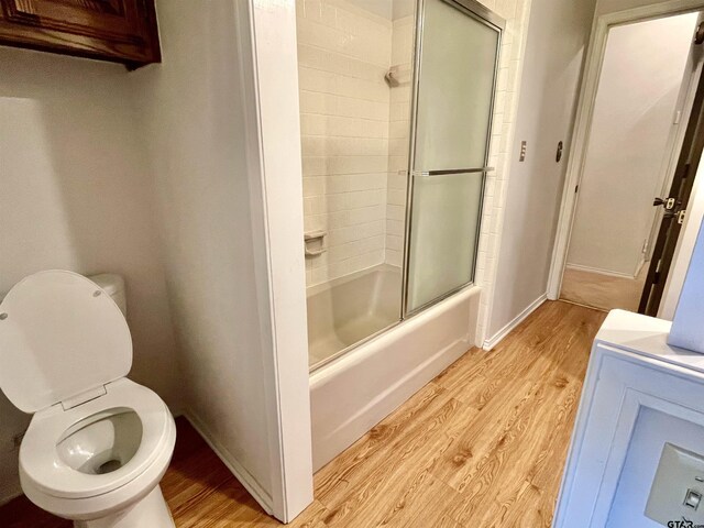 609 Francis St, Hawkins, TX 75765 - bathroom with wood finished floors, combined bath / shower with glass door, toilet, and baseboards