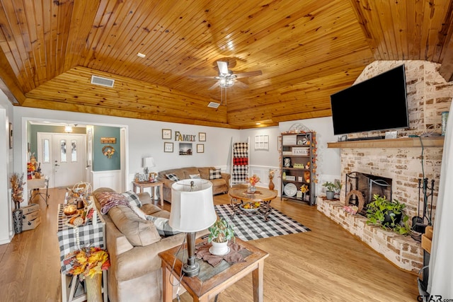 living room featuring wooden ceiling, hardwood / wood-style flooring, a fireplace, and ceiling fan