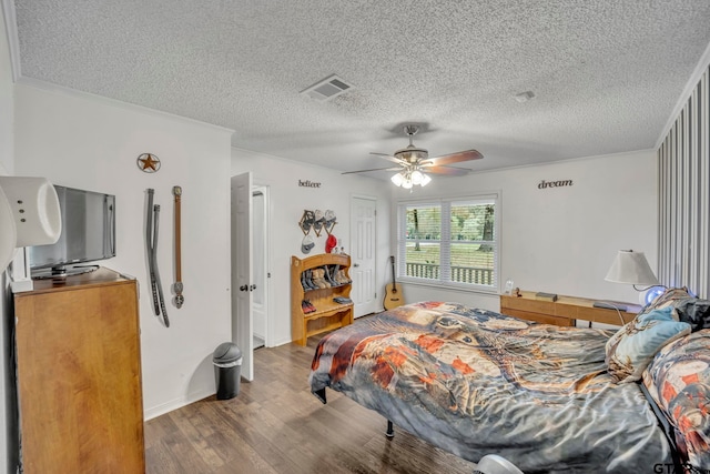 bedroom with ornamental molding, hardwood / wood-style floors, ceiling fan, and a textured ceiling