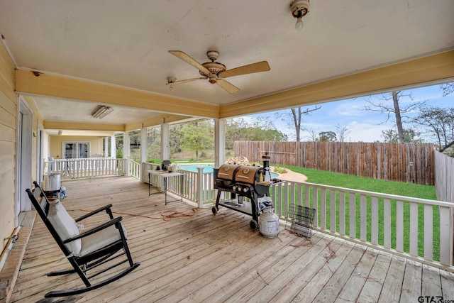 deck with ceiling fan, a lawn, and a fenced in pool