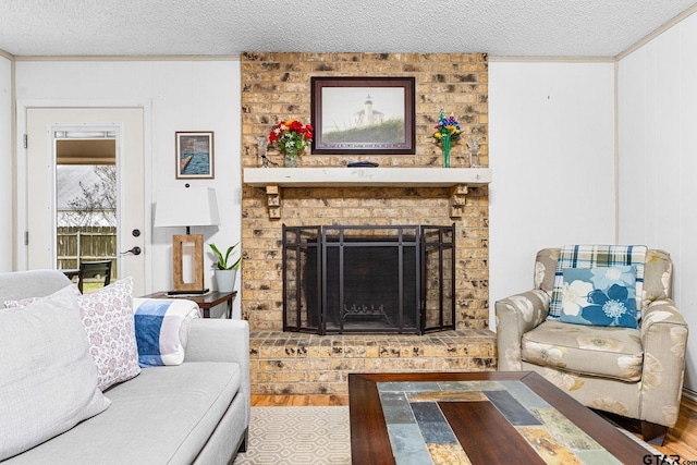 living room with wood-type flooring, a fireplace, and a textured ceiling