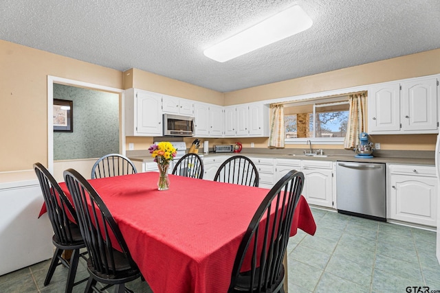 dining space featuring a textured ceiling and sink