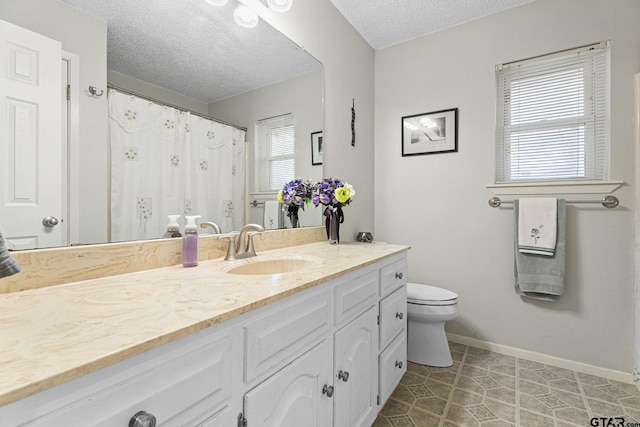 bathroom featuring tile patterned floors, a textured ceiling, toilet, and vanity