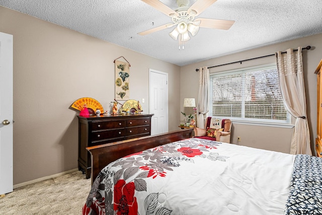 bedroom featuring ceiling fan, light colored carpet, and a textured ceiling