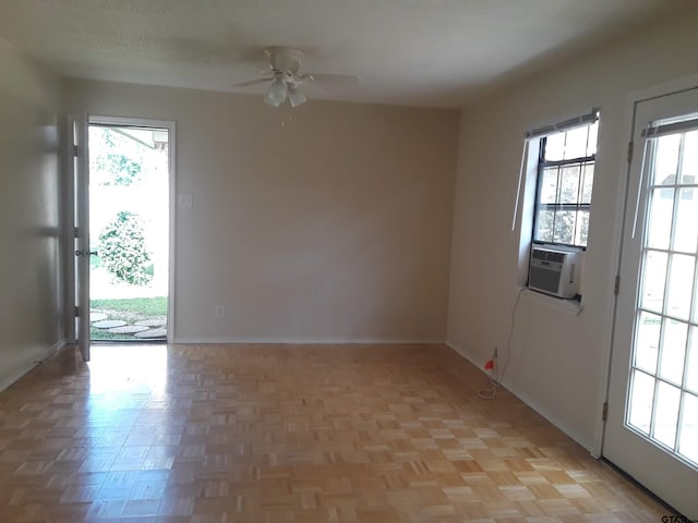 spare room featuring cooling unit, ceiling fan, plenty of natural light, and light parquet floors