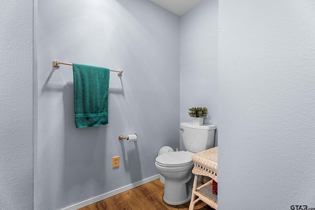 bathroom featuring hardwood / wood-style flooring and toilet