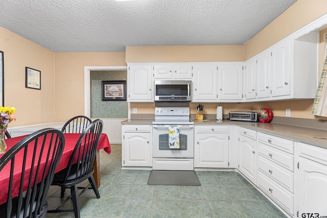 kitchen with white cabinets, electric range, and a textured ceiling