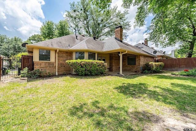 3110 Oleander Dr, Tyler, TX 75707 - back of property featuring a chimney, brick siding, fence, a patio area, and a lawn