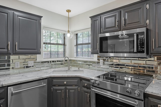 3110 Oleander Dr, Tyler, TX 75707 - kitchen with light stone countertops, hanging light fixtures, stainless steel appliances, backsplash, and a sink