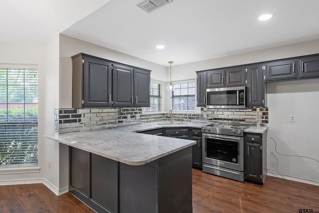 3110 Oleander Dr, Tyler, TX 75707 - kitchen with a sink, visible vents, a peninsula, appliances with stainless steel finishes, and dark wood finished floors