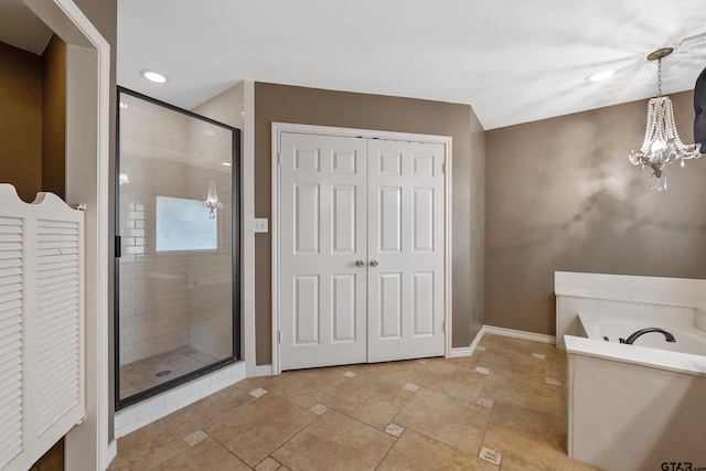 3110 Oleander Dr, Tyler, TX 75707 - bathroom featuring an inviting chandelier, a shower stall, a closet, baseboards, and a garden tub