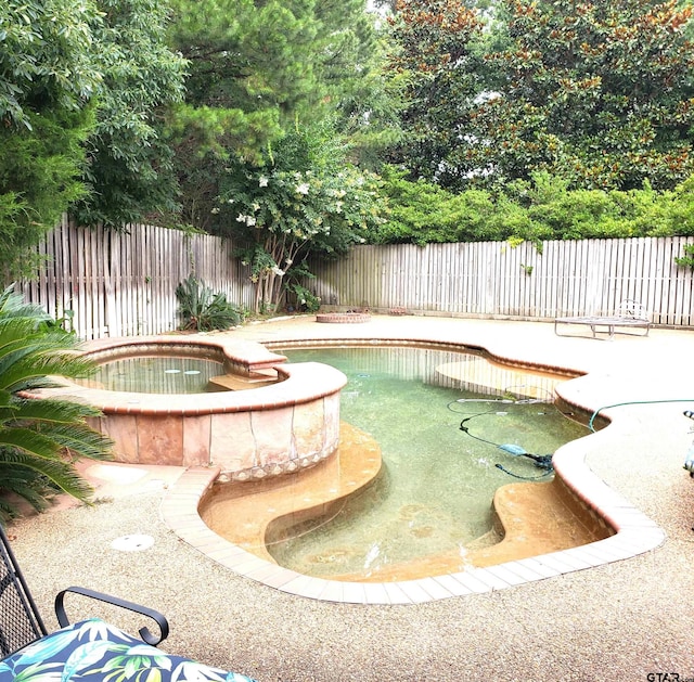 view of pool featuring an in ground hot tub