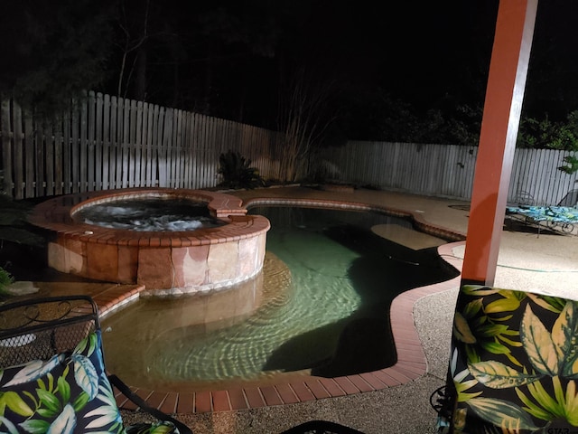 view of swimming pool with an in ground hot tub