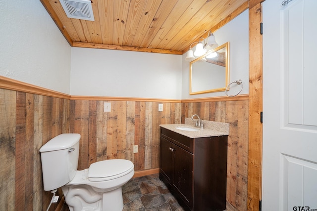 bathroom with wooden ceiling, wood walls, crown molding, toilet, and vanity